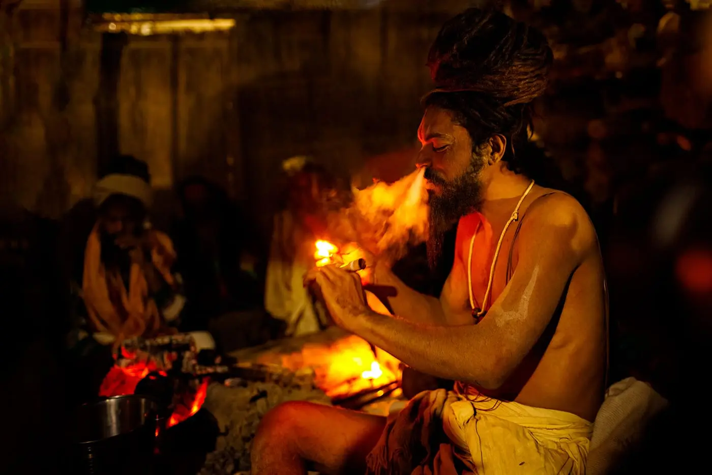 A Naga Sadhu smokes a chillum at the Maha Kumbh Mela in Allahabad, India