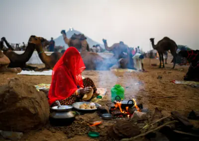 Wife of a camel herder is preparing food during Pushkar Mela, Rajasthan.